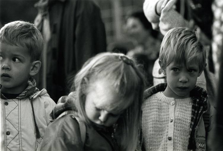 Three children in a row. All looking anxious.