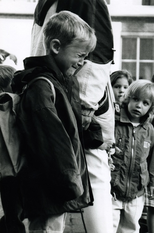 A little boy biting his lip and trying very hard not to cry - but failing. A little girl is looking at him.